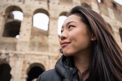 Cheerful Asian traveler outside famous landmark
