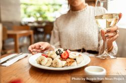 Woman in gray sweater drinking wine and having a dessert 4mwqo0