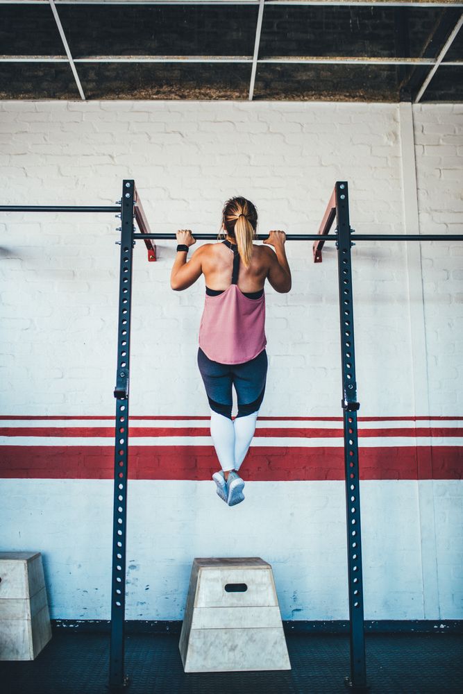 Woman doing a pull up in the gym