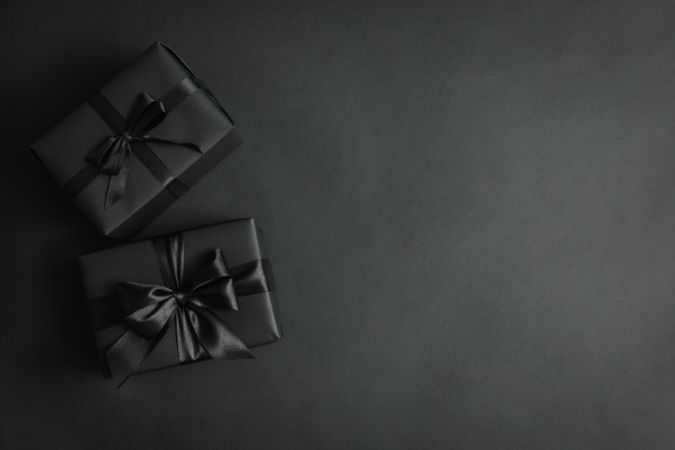 Gift boxes with dark bows on dark background