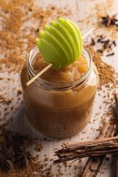Delicious applesauce in glass jar and cinnamon