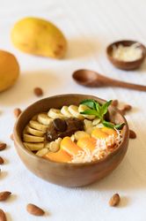 Bowl with delicious fruits placed on table