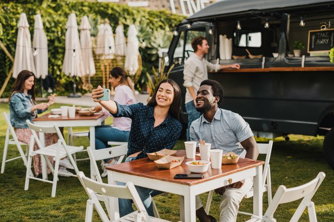 Diverse friends taking selfie outside food truck