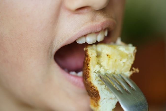 Girl biting into breakfast on fork