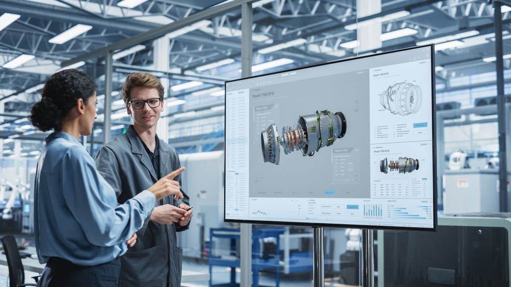 Male and female colleagues working from presentation screen