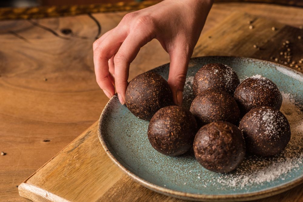 Chef putting chocolate truffle on ceramic plate