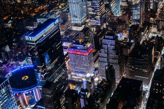 Helicopter Tour of New York City Architecture at Night. Fly-By Over Midtown Manhattan Office Buildings and Skyscrapers Towards Madison Square Garden. Aerial Urban Landscape with Lights in the Evening