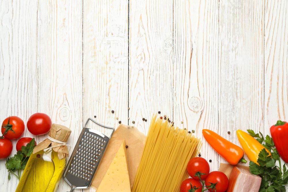 Composition with pasta and ingredients for cooking on wooden background, top view