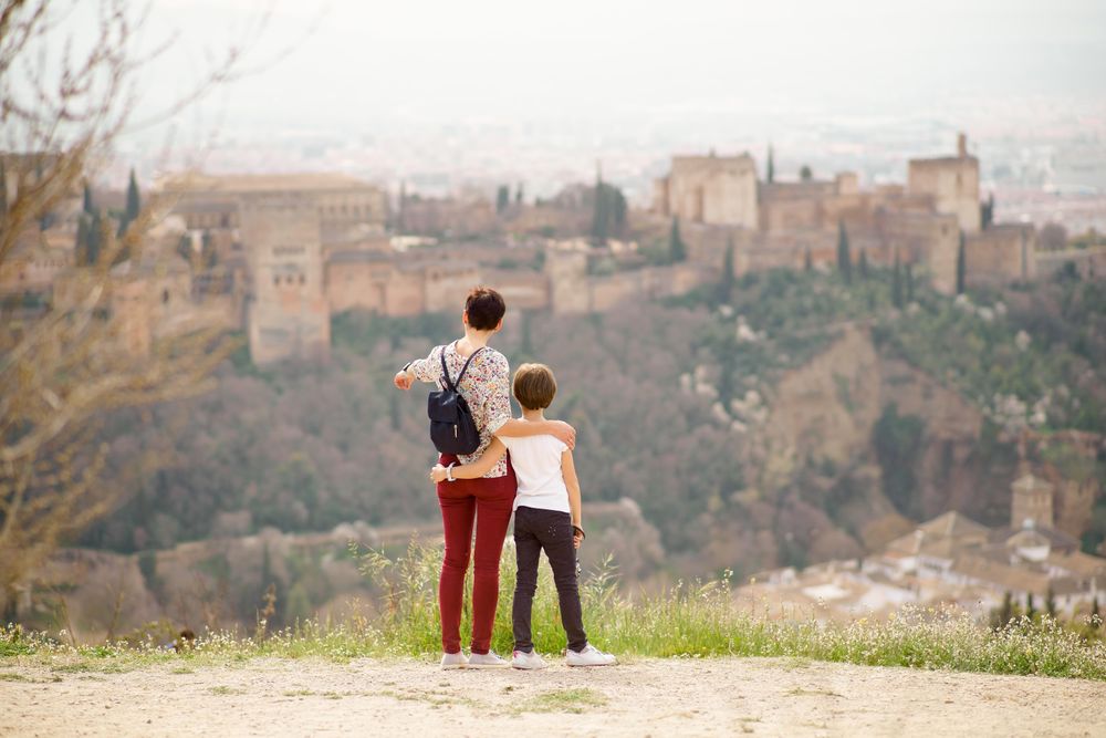 Mother pointing down at Spanish town with her daughter