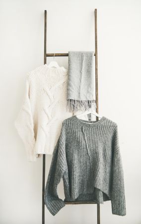 Woolen sweaters, grey scarf on modern garment rack