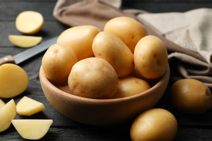Ceramic bowl full of potatoes on kitchen counter with wedges