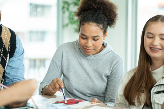 Girl in arts class, seated with friends