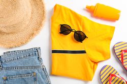 Sea vacation accessories on yellow background, top view