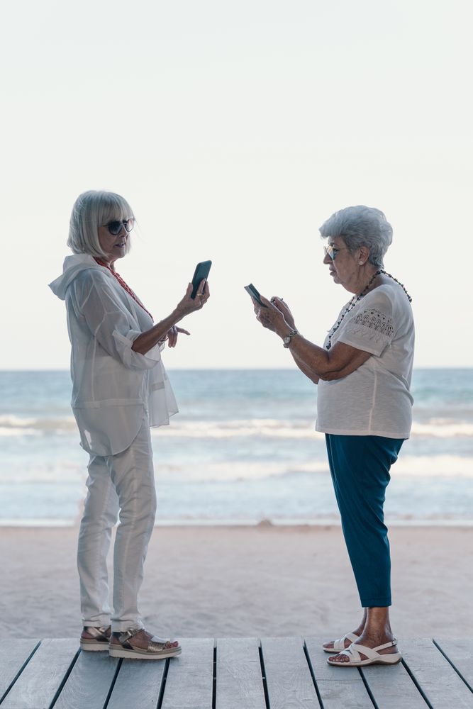 mature females using phones on beach