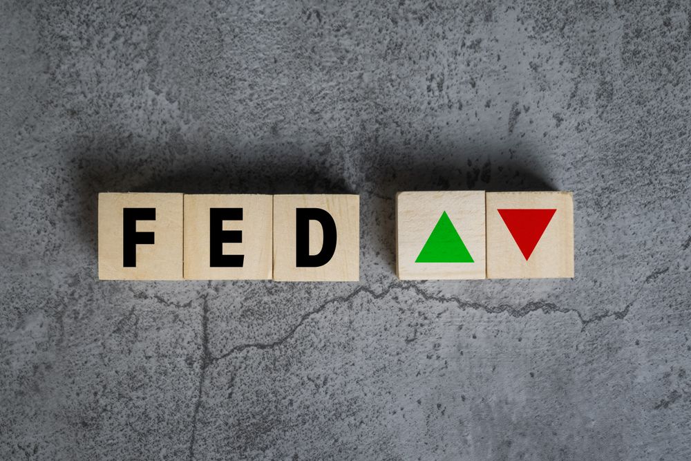 the fed or federal reserve with up and down arrow on wooden blocks on cement background