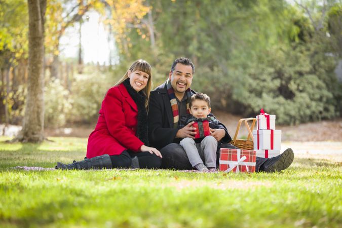 Family Enjoying Christmas Gifts in the Park Together