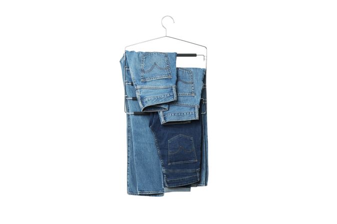 Jeans on hangers, isolated on light background