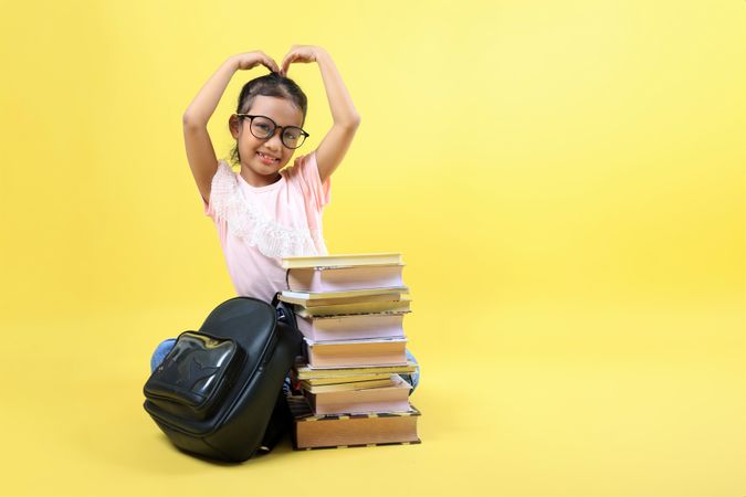 Asian Kid Happy Expression Love Sign with Book