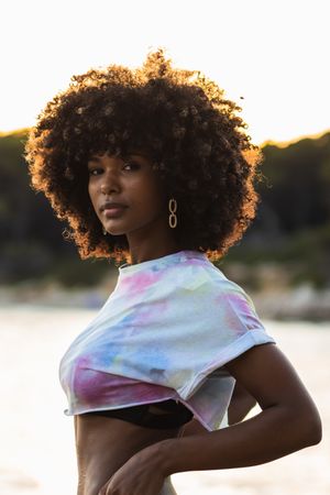 Unemotional Black woman standing on seashore