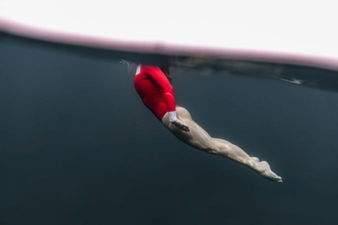 Woman diving in blue waving water