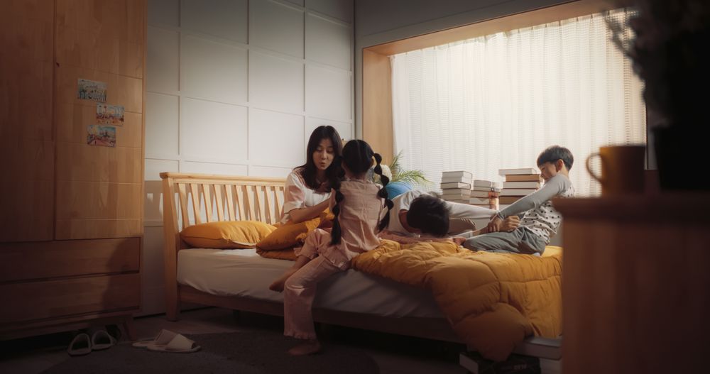 Happy Korean Family in the Morning: Active and Playful Children Running to Their Parents' Bedroom to Wake Them Up.