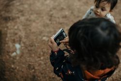 Little girl looking at the display screen on a camera