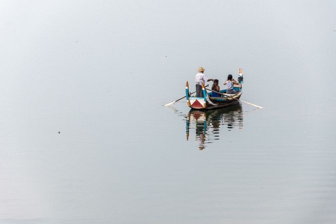Three people on boat in the middle of the sea