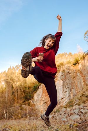 Young woman with smartphone dancing