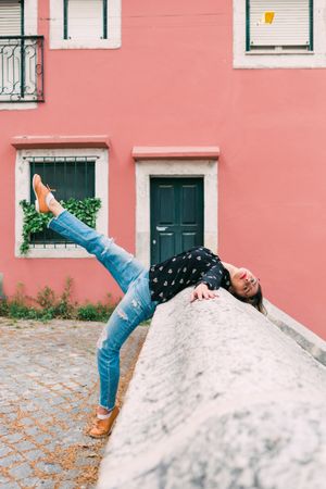 Casual woman dancing on old city street