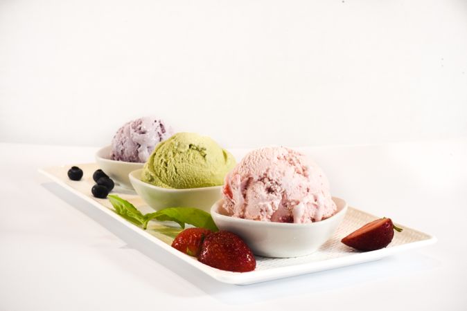 Three small bowls of colorful ice cream