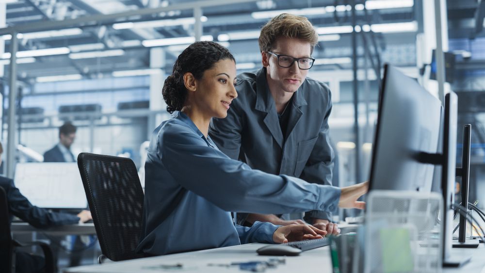 White Man and Hispanic Woman Having Conversation at Industrial Facility.