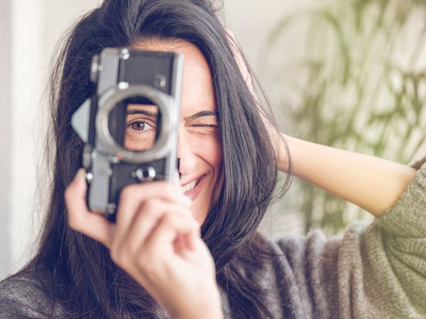 Winking woman with retro photo camera