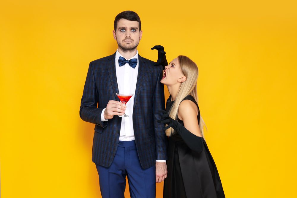 Concept of Halloween, young man and woman on yellow background
