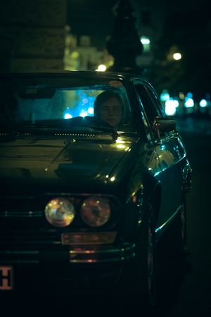 Man driving an old car at night