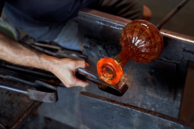Crop man using instrument while forming vase