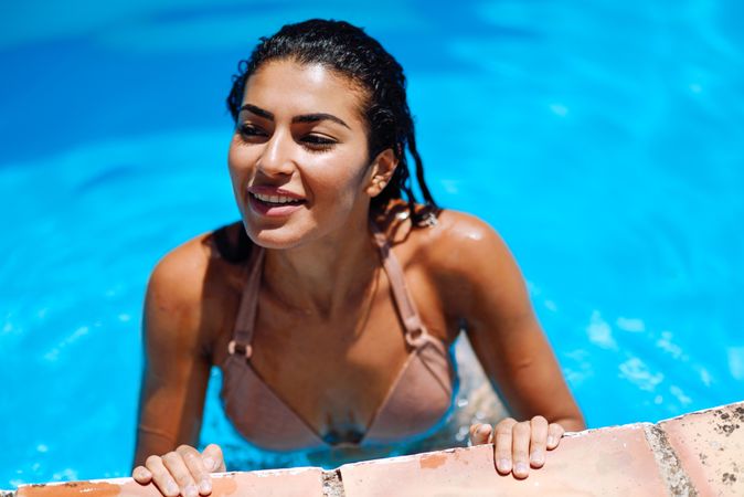 Side view of Arab woman getting out of swimming pool