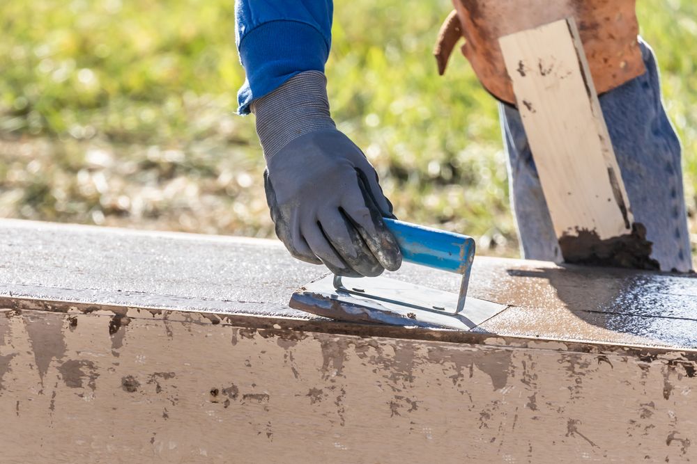 Construction Worker Using Hand Groover On Wet Cement Forming Coping Around New Pool