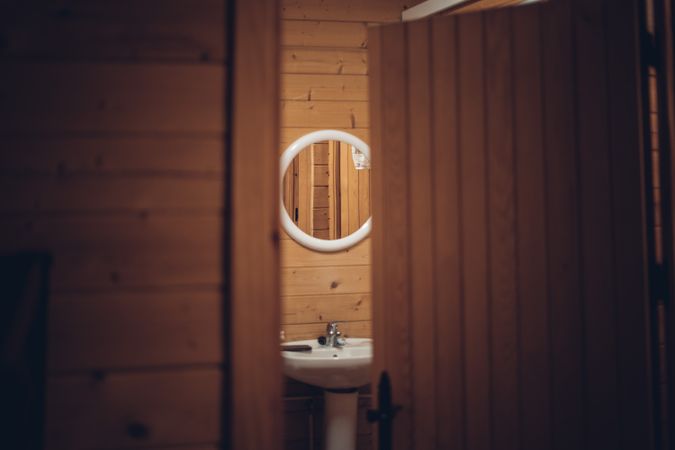 Bathroom in wooden house with opened door