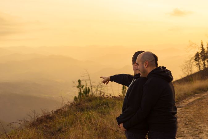 Men hugging on road on hill
