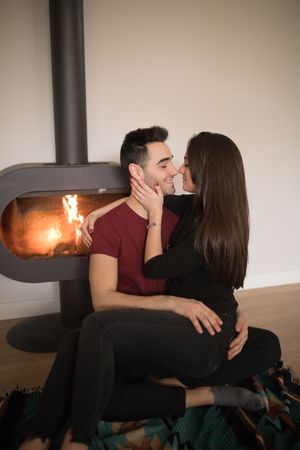 Couple sitting near fireplace on floor
