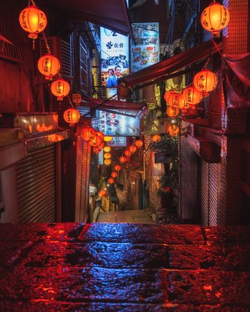 Red lit lanterns decorating the alley at night