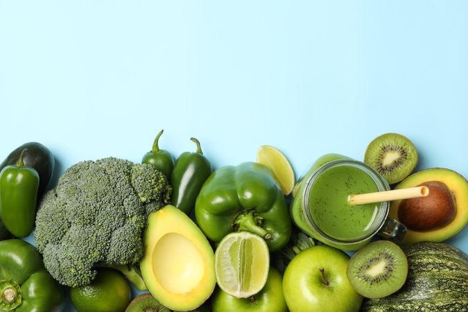 Vegetables, fruits and smoothie on blue background