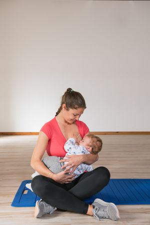 Mother feeding baby in gym