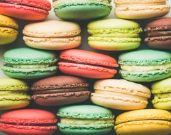 Bright multi-colored macaron pastries tightly stacked, side view, horizontal composition, close up