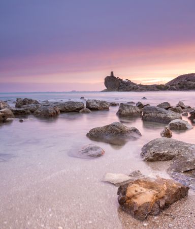 Sundown sky over sea and stony coast