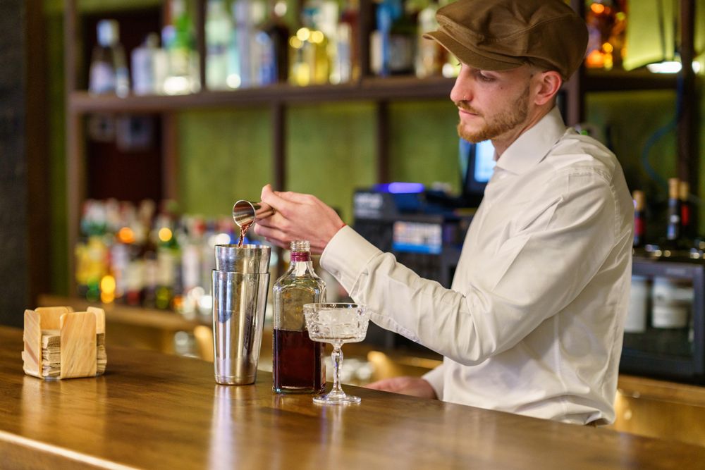 Bartender mixing shots in a shaker for cocktail