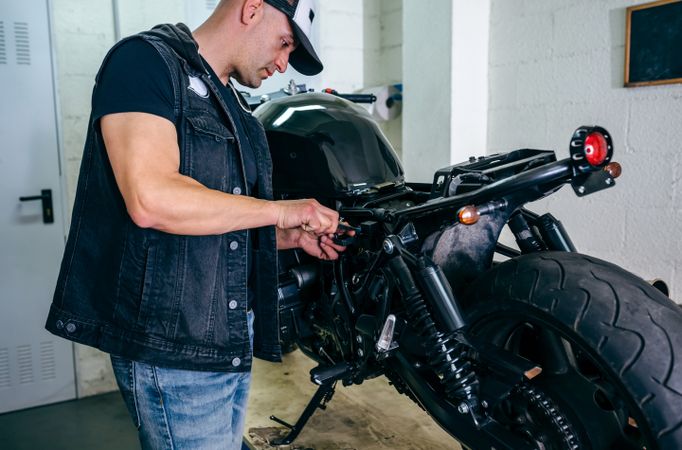 Motorcycle mechanic changing a fuse