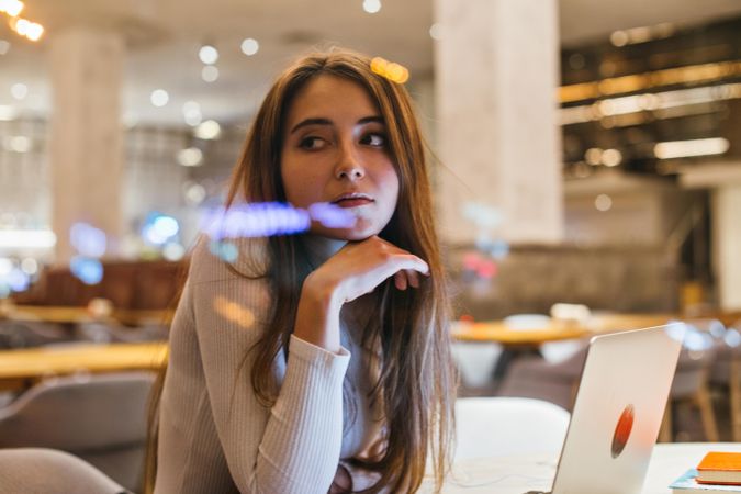 Female student looking around from her restaurant table