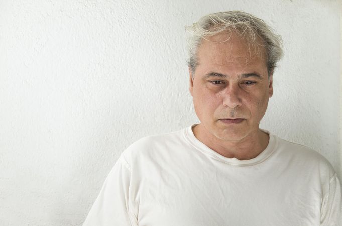 Portrait of unhappy middle aged man in light shirt