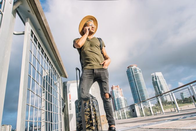 Traveller young man talking on the cellphone ready for departure.